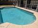 Backyard pool features a tiled edge with patio and seating areas, perfect for outdoor relaxation at 2649 N 85Th Ave, Phoenix, AZ 85037
