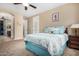 Bright bedroom features a ceiling fan, ensuite bathroom, and a comfortable bed with decorative pillows at 2680 E Lodgepole Dr, Gilbert, AZ 85298