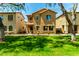 Two-story home with tan stucco, tile roof, well-maintained lawn, and mature trees at 3485 S Seneca Way, Gilbert, AZ 85297