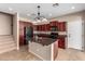 Eat in kitchen featuring cherry cabinets, tile backsplash, granite countertops and island at 3485 S Seneca Way, Gilbert, AZ 85297