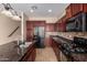 Well-lit kitchen featuring granite countertops, cherry cabinets and modern stainless-steel appliances at 3485 S Seneca Way, Gilbert, AZ 85297