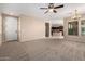 Open-concept living room with neutral walls, access to kitchen, and a ceiling fan at 3485 S Seneca Way, Gilbert, AZ 85297