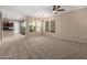 Carpeted living room with ample natural light from large windows and sliding glass doors at 3485 S Seneca Way, Gilbert, AZ 85297