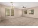 Spacious carpeted living room illuminated by a chandelier and multiple windows at 3485 S Seneca Way, Gilbert, AZ 85297