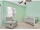 Bedroom with a glider chair, and a white crib; the walls are painted a soft mint green at 3566 S Colorado St, Chandler, AZ 85286