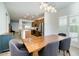 Open-concept dining area with a view to the kitchen, featuring wood floors and a modern light fixture at 3566 S Colorado St, Chandler, AZ 85286