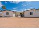 Backyard showing the property's exterior and an empty lot under a partially cloudy sky at 3802 W Mission Ln, Phoenix, AZ 85051