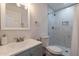Updated bathroom features marble tiled shower, toilet and gray vanity with modern fixtures at 3802 W Mission Ln, Phoenix, AZ 85051