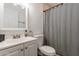 A well-lit bathroom featuring a sink, toilet, and a shower with a stylish patterned shower curtain at 3802 W Mission Ln, Phoenix, AZ 85051