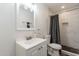 Updated bathroom features marble tiled shower with black accents, white vanity and modern fixtures at 3802 W Mission Ln, Phoenix, AZ 85051