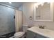 Updated bathroom features marble tiled shower with black accents, gray vanity and modern fixtures at 3802 W Mission Ln, Phoenix, AZ 85051