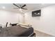 A cozy bedroom featuring a ceiling fan, a TV mounted on the wall, and wood-look flooring at 3802 W Mission Ln, Phoenix, AZ 85051