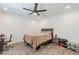 An inviting bedroom with wood-look floors, ceiling fan, and a functional workspace, offering a comfortable retreat at 3802 W Mission Ln, Phoenix, AZ 85051