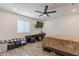 A spacious bedroom with a ceiling fan, a TV, wood-look flooring, and a window for natural light at 3802 W Mission Ln, Phoenix, AZ 85051