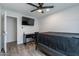 This bedroom offers a ceiling fan, TV, desk, and wood-style flooring at 3802 W Mission Ln, Phoenix, AZ 85051