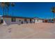 Attractive white brick home with a modern black roof, ample parking, and mature trees under a clear blue sky at 3802 W Mission Ln, Phoenix, AZ 85051
