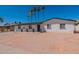Inviting single-level home boasting a pristine white facade, complemented by drought-tolerant landscaping and a clear blue sky at 3802 W Mission Ln, Phoenix, AZ 85051
