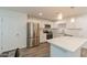 A modern kitchen with white cabinets, stainless steel appliances, quartz counters, and a center island with pendant lights at 3802 W Mission Ln, Phoenix, AZ 85051