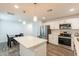 Well-lit kitchen featuring white cabinetry, stainless steel appliances, a functional island, and a dining area at 3802 W Mission Ln, Phoenix, AZ 85051