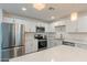 A well-equipped kitchen featuring stainless steel appliances, white cabinets, quartz countertops and an island at 3802 W Mission Ln, Phoenix, AZ 85051