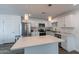 Bright kitchen features stainless appliances, white cabinetry, and a large center island with quartz countertop at 3802 W Mission Ln, Phoenix, AZ 85051