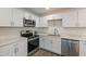 Modern kitchen featuring stainless steel appliances, white cabinets, a double sink and quartz countertops at 3802 W Mission Ln, Phoenix, AZ 85051