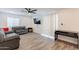 Bright living room featuring wood-look flooring, a ceiling fan, and a sliding glass door for plenty of natural light at 3802 W Mission Ln, Phoenix, AZ 85051