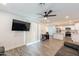 Open concept living area with sleek flooring, modern ceiling fan, and a view into the adjacent, updated kitchen at 3802 W Mission Ln, Phoenix, AZ 85051
