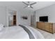 Comfortable bedroom featuring a warm palette, ceiling fan, and dresser storage with television at 3843 E Hazeltine Way, Chandler, AZ 85249