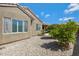 Backyard featuring gravel landscaping, mature trees, a covered patio, and neutral-toned exterior at 3843 E Hazeltine Way, Chandler, AZ 85249