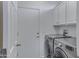 Well-equipped laundry room featuring modern washer and dryer, storage cabinets and access door at 3843 E Hazeltine Way, Chandler, AZ 85249