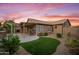 A spacious backyard featuring a covered patio and artificial grass at 4020 N 151St Dr, Goodyear, AZ 85395