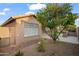 Side view of the property showing a covered patio, desert landscaping, a paver walkway, and a lush tree at 4020 N 151St Dr, Goodyear, AZ 85395