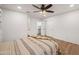 This bedroom has wood-look floors, a ceiling fan, and access to an en-suite bathroom at 4020 N 151St Dr, Goodyear, AZ 85395