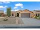 A home featuring desert landscaping, large driveway, and cozy design creates a welcoming curb appeal at 4020 N 151St Dr, Goodyear, AZ 85395