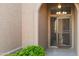 Inviting front porch featuring an arched entrance, security door, a 'hello' welcome mat, and lush greenery at 4020 N 151St Dr, Goodyear, AZ 85395