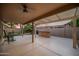 Underneath a covered patio is an outdoor kitchen and seating for entertaining at 4020 N 151St Dr, Goodyear, AZ 85395