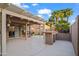 Well-designed outdoor living space featuring a covered patio, outdoor bar, lush greenery, and access to backyard at 4020 N 151St Dr, Goodyear, AZ 85395
