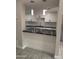 Kitchen with white cabinets, black countertops, stainless steel sink, and subway tile backsplash, open to living space at 4043 W Palomino Rd, Phoenix, AZ 85019