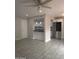 Open-concept living area with tile flooring, ceiling fan, and a passthrough to the updated kitchen with stainless refrigerator at 4043 W Palomino Rd, Phoenix, AZ 85019