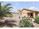 An inviting back yard with desert landscaping, a palm tree, and a cozy seating area at 41341 W Little Dr, Maricopa, AZ 85138