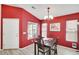 Bright dining room with high ceilings, bold red walls, and large windows, perfect for Gathering meals and entertaining guests at 41341 W Little Dr, Maricopa, AZ 85138