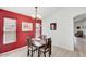 Inviting dining room with a dark wood table and decorative red accent wall, flooded with natural light from dual windows at 41341 W Little Dr, Maricopa, AZ 85138
