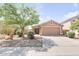 Well-maintained single-story home featuring desert landscaping, a two-car garage, and mature trees at 41341 W Little Dr, Maricopa, AZ 85138