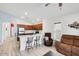 Open concept living space featuring a modern kitchen, breakfast bar, and comfortable seating area at 41341 W Little Dr, Maricopa, AZ 85138