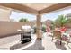 A covered patio with outdoor seating, grill, and desert landscaping at 41341 W Little Dr, Maricopa, AZ 85138