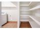 Bright laundry room featuring tile floors, a washer, and storage shelves at 4153 W Sunnyside Ave, Phoenix, AZ 85029
