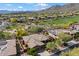 Aerial view of houses in a desert community with golf course, solar panels, and mountain views at 41910 N Long Cove Way, Anthem, AZ 85086