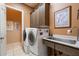 Well-equipped laundry room features stainless steel sink, cabinets, washer and dryer at 41910 N Long Cove Way, Anthem, AZ 85086