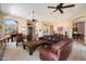 Open living room featuring a leather sectional sofa, a rustic coffee table, and a piano at 41910 N Long Cove Way, Anthem, AZ 85086